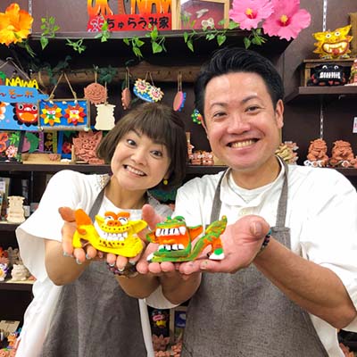 絵付けしたシーサーを持って笑顔の夫婦