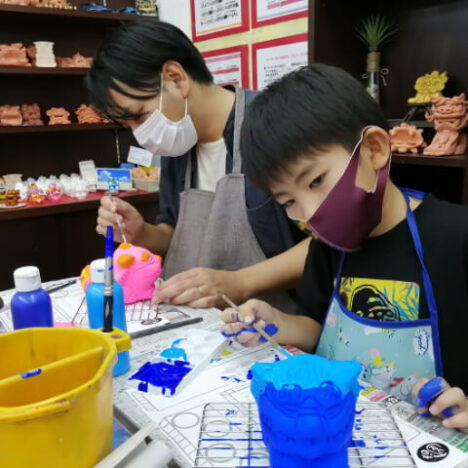 幸せシーサーに絵付けする男の子