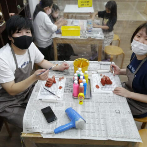 シーサー絵付けをする女性