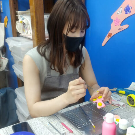 作ったシーサーに絵付けする女性