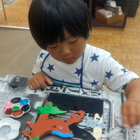 時計に絵付けしている男の子
