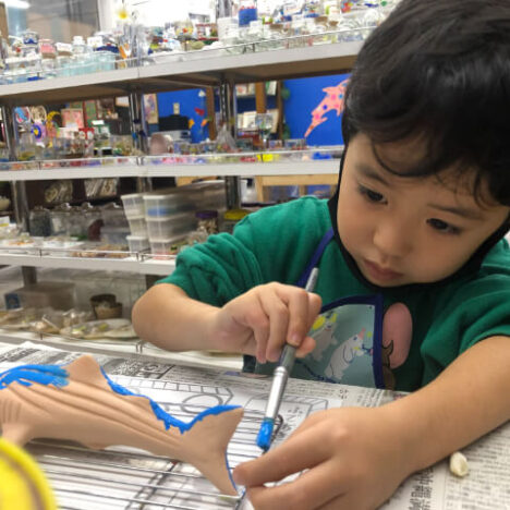 ジンベエザメに絵付けしている男の子