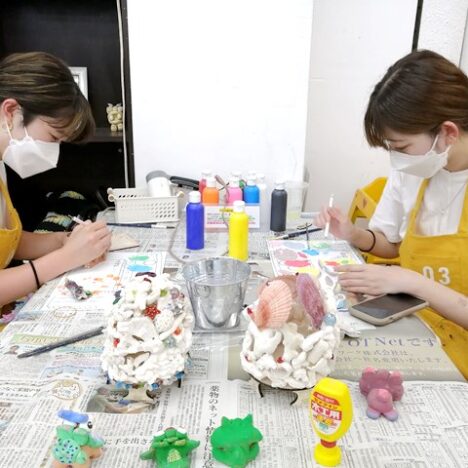シーサーの絵付けをしている2人の女性